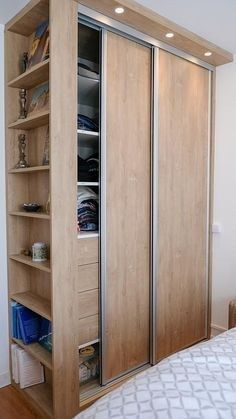 a bed sitting next to a wooden book shelf