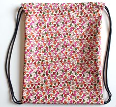 a drawstring bag with an orange, pink and green pattern on the front