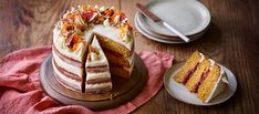 a cake sitting on top of a wooden table next to a plate with a slice cut out of it