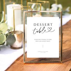 there is a sign that says dessert table on the table next to candles and flowers