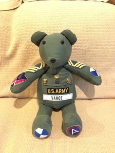 an army teddy bear sitting on top of a couch