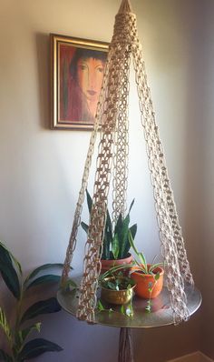 a hammock hanging in the corner of a room with potted plants on it