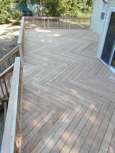 a wooden deck with stairs leading up to the door