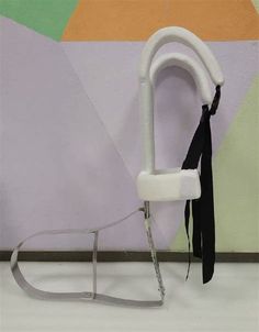 a white chair with a black tie hanging from it's back and an umbrella in the background