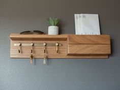 a wooden shelf with keys, glasses and a potted plant sitting on top of it