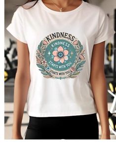 a woman wearing a white t - shirt that says kindness starts with you