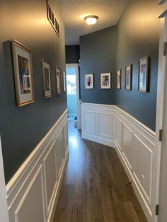 an empty hallway with blue walls and white waives on the wall, wood flooring