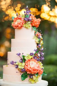 a wedding cake decorated with flowers and greenery