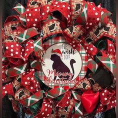 a red and green christmas wreath with a black dog on it