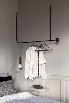 a bedroom with clothes hanging on a rail