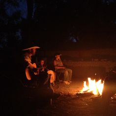 people sitting around a campfire at night