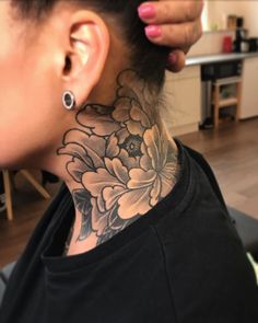 a woman with a flower tattoo on her neck