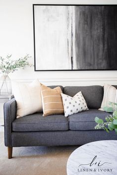 a living room filled with furniture and a large painting on the wall above it's couch