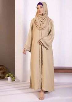 Abaya & hijab set for Women. Description : Abaya : Full length abaya in soft, drapey fabric. Button through front opening. V neckline. Full sleeves with diamanté and pleats detail. Material : Nidha Color: Beige Country : Made in Pakistan Modest Solid Color Floor-length Abaya, Modest Floor-length Abaya, Long Thobe With Modesty Panel For Eid, Solid Color Abaya With Modesty Panel For Eid, Solid Long Thobe For Eid, Long Thobe For Eid, Eid Abaya With Modesty Panel In Solid Color, Long Abaya With Modesty Panel, Modest Abaya With Modesty Panel For Eid