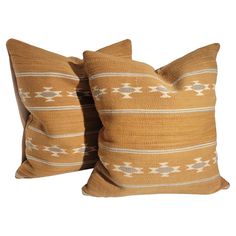 two brown and white pillows sitting next to each other