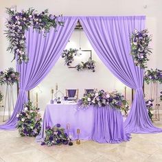 a table covered in purple cloths and flowers