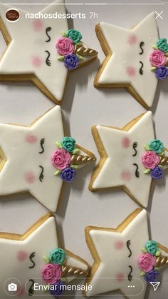 some decorated cookies are arranged in the shape of stars and unicorns with flowers on them