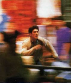 a blurry photo of a man leaning on a rail