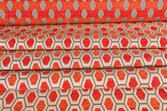 an orange and grey patterned fabric with white dots on the top, in three rows