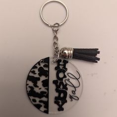 a black and white keychain with a tassel hanging from it's side