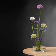 a vase filled with flowers sitting on top of a wooden table