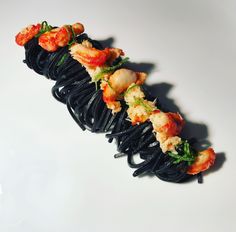 there are many pieces of food on the black noodles