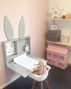 a child's room with pink walls and toys on the desk, including a stuffed bunny