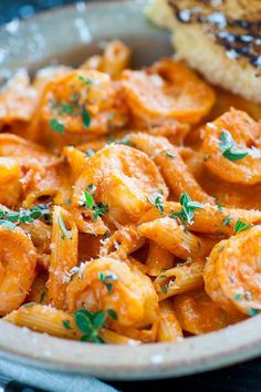 pasta with shrimp and parmesan cheese in a bowl next to toasted bread