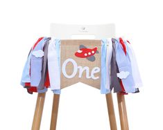 a wooden chair with a one sign on it's back and some ribbons around the legs