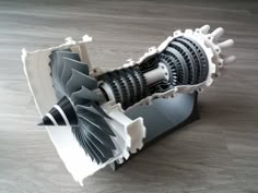 a model of an engine on a wooden table with it's front end partially open