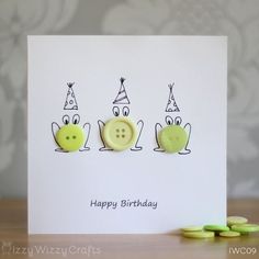 a card with three cartoon faces on it and some green buttons in front of them