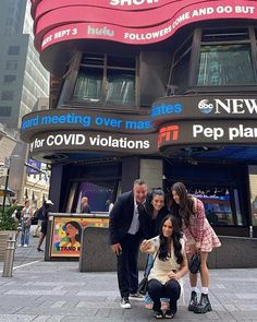 four people standing in front of a building