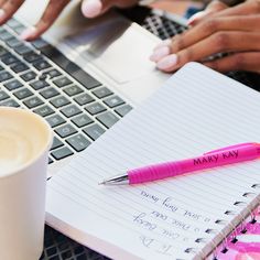 two people are working on their laptops and one is writing in a notepad