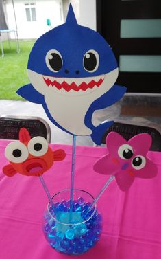 a table topped with cupcake toppers and paper cut out shark heads on sticks