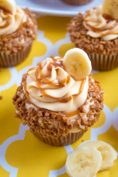 some cupcakes with banana slices and frosting