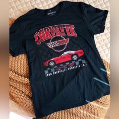 a black corvette t - shirt sitting on top of a bed