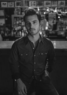 a man standing in front of a bar with his hands on his hips and looking at the camera