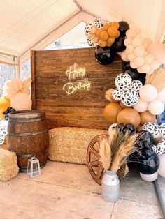 an outdoor birthday party with balloons and hay