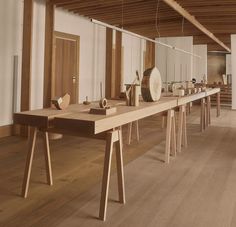 a large wooden table sitting in the middle of a room filled with vases and other items