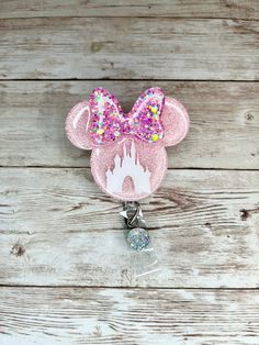 a pink minnie mouse badge holder on a wooden background