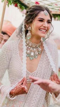 a woman in a wedding dress is smiling and holding her hand out to another person