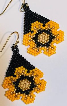 the beaded earrings are decorated with yellow and black beads