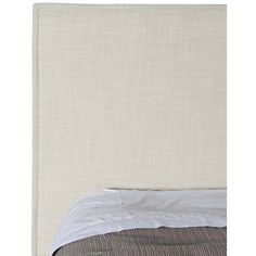 an upholstered headboard with white linen