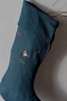 a blue christmas stocking with embroidered birds on it