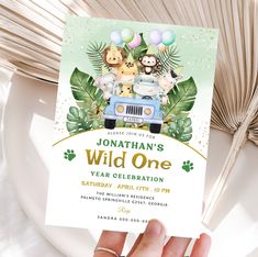 a person holding up a card for a wild one birthday party with animals on it