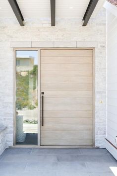 the front door to a house with white brick walls