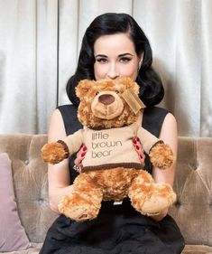 a woman sitting on a couch with a teddy bear in her lap and the caption little brown bear