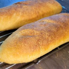 two loaves of bread cooling on a rack