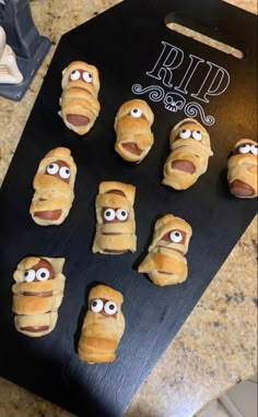 hot dog buns with googly eyes on a black board