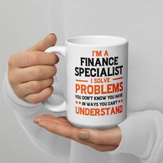 a person holding a coffee mug with the words i'm a finance specialist on it